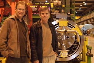 Joe (r) with Erik in front of LHC superconducting accelerator element.